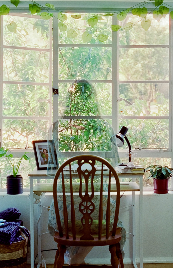 Picture of person (absent) in profile sitting at her home's table, absence speaks of precarity