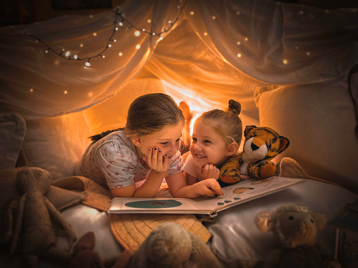 Two children in a cubby reading